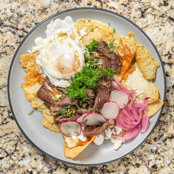 Overhead view of San Jose Mexican Restaurant's chilaquiles with steak, fried egg, pickled onions, and radishes.